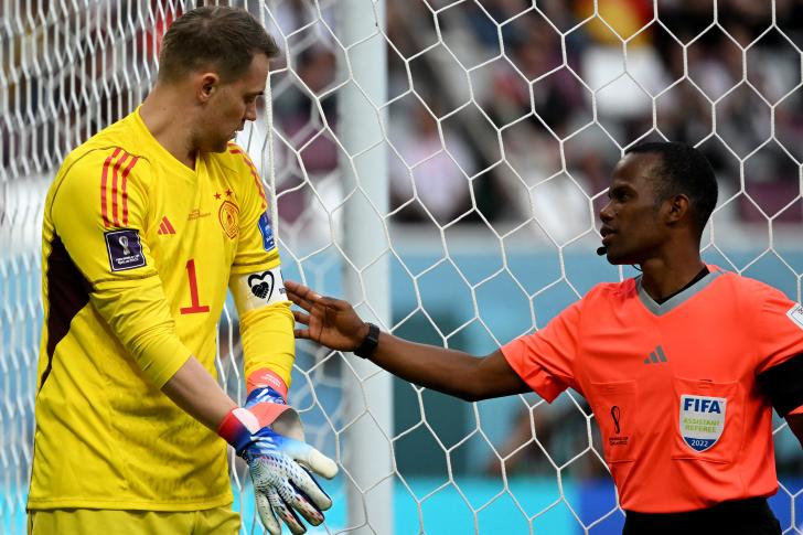 An assistant referee checks on the the captain-s armband on Germany's goalkeeper #01 Manuel Neuer ahead of the Qatar 2022 World Cup Group E football match between Germany and Japan at the Khalifa International Stadium in Doha on November 23, 2022. (Photo by INA FASSBENDER / AFP)