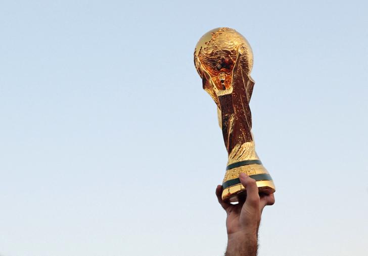 Soccer Football - FIFA World Cup Qatar 2022 Tunisia Fan Activity - Doha, Qatar - November 11, 2022 A Tunisia fan displays a replica World Cup trophy at Souq Waqif REUTERS/Amr Abdallah Dalsh